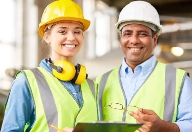 Man and Woman in yellow high vis jackets holding a tablet device