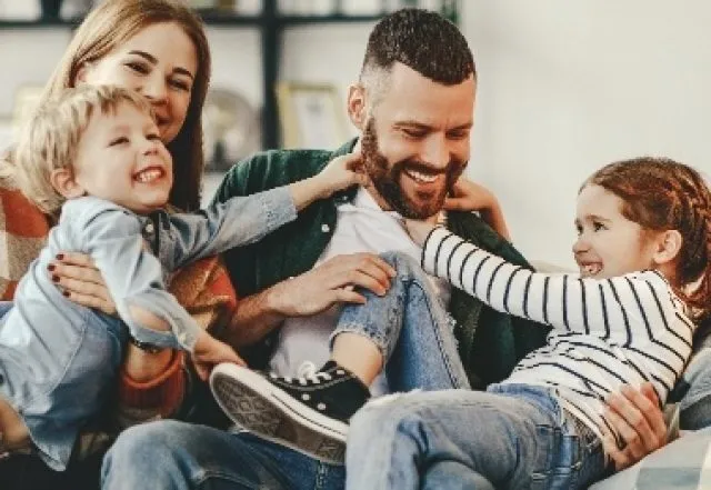 family of four playful wrestling at home