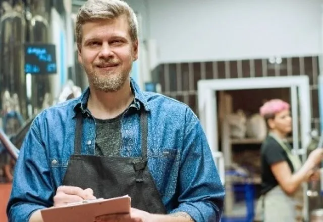 man in a workshop holding a tablet device